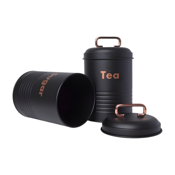 Set of three black metal kitchen canisters with rose gold handles, labelled coffee, tea, and sugar respectively. PALM GIFTS