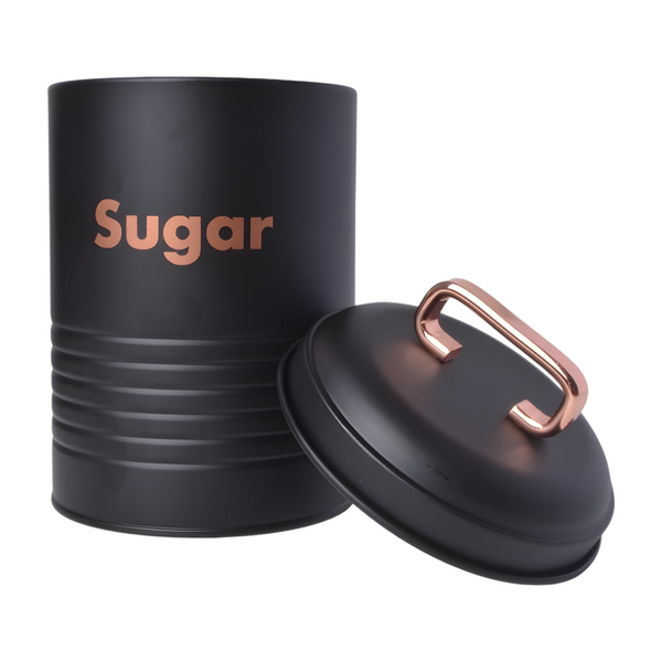 Set of three black metal kitchen canisters with rose gold handles, labelled coffee, tea, and sugar respectively. PALM GIFTS