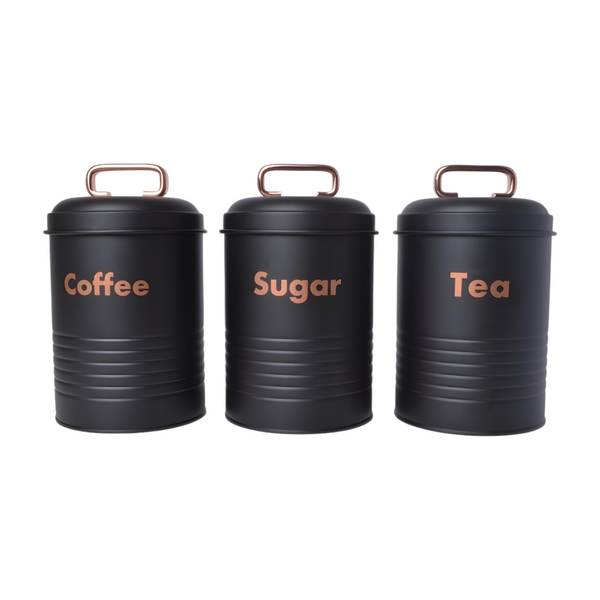 Set of three black metal kitchen canisters with rose gold handles, labelled coffee, tea, and sugar respectively. PALM GIFTS