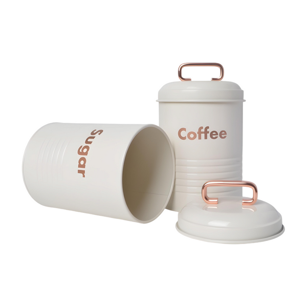 Three white kitchen canisters with rose gold lids, each labelled with a different word: coffee, sugar, and tea. PALM GIFTS