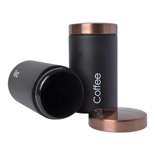 Set of three black metal kitchen canisters with rose gold lids, labelled sugar, tea, and coffee. PALM GIFTS