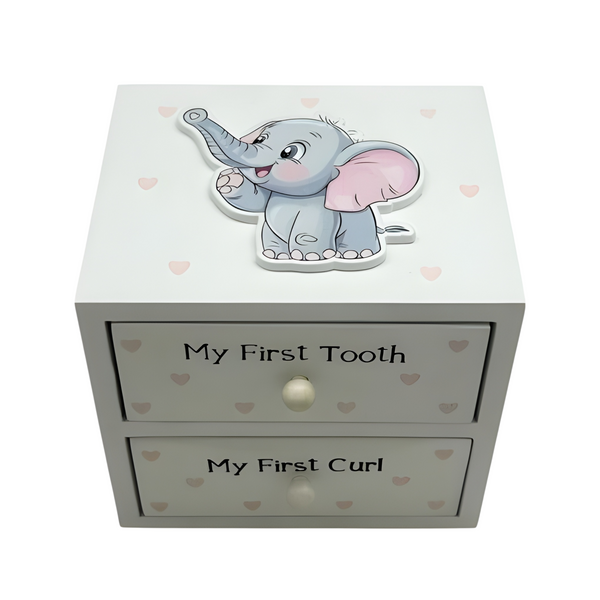 A baby keepsake box with two drawers labelled 'My First Tooth' and 'My First Curl', featuring a cute grey 3D elephant decoration on top and small pink hearts printed on the front. PALM GIFTS
