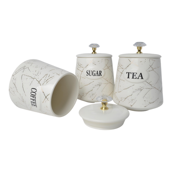Three white ceramic kitchen canisters with gold marble design and gold handles, each labelled with different contents: coffee, sugar, and tea.